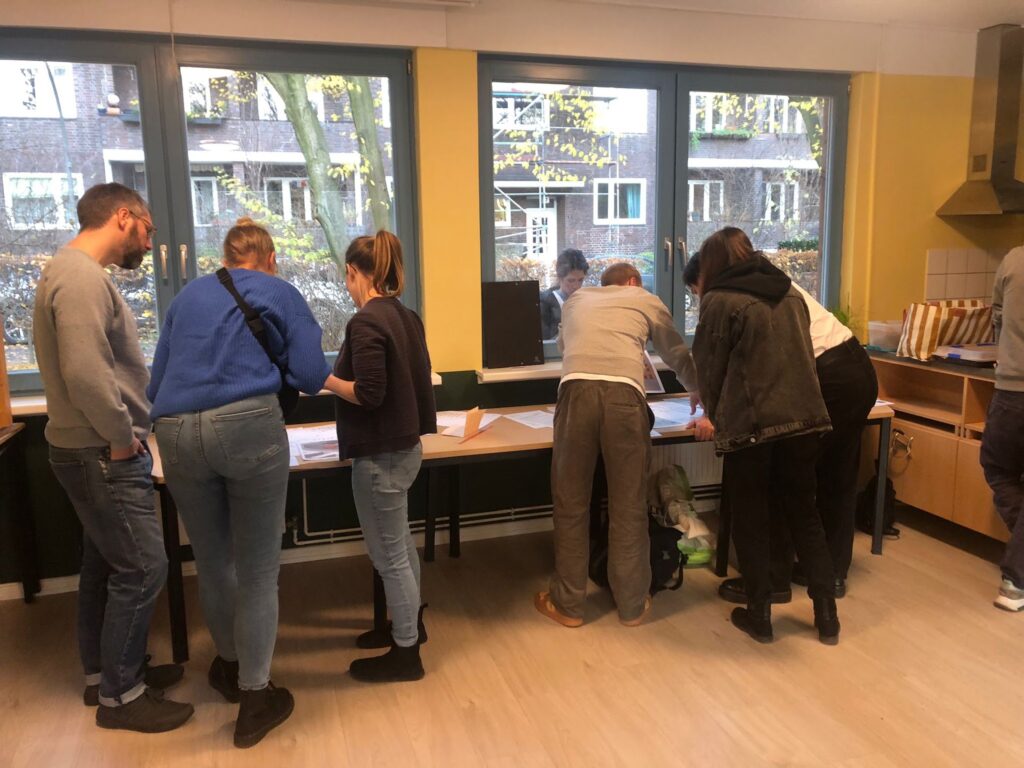 Interessierte schauen sich beim Kennenlerntreffen die Pläne an