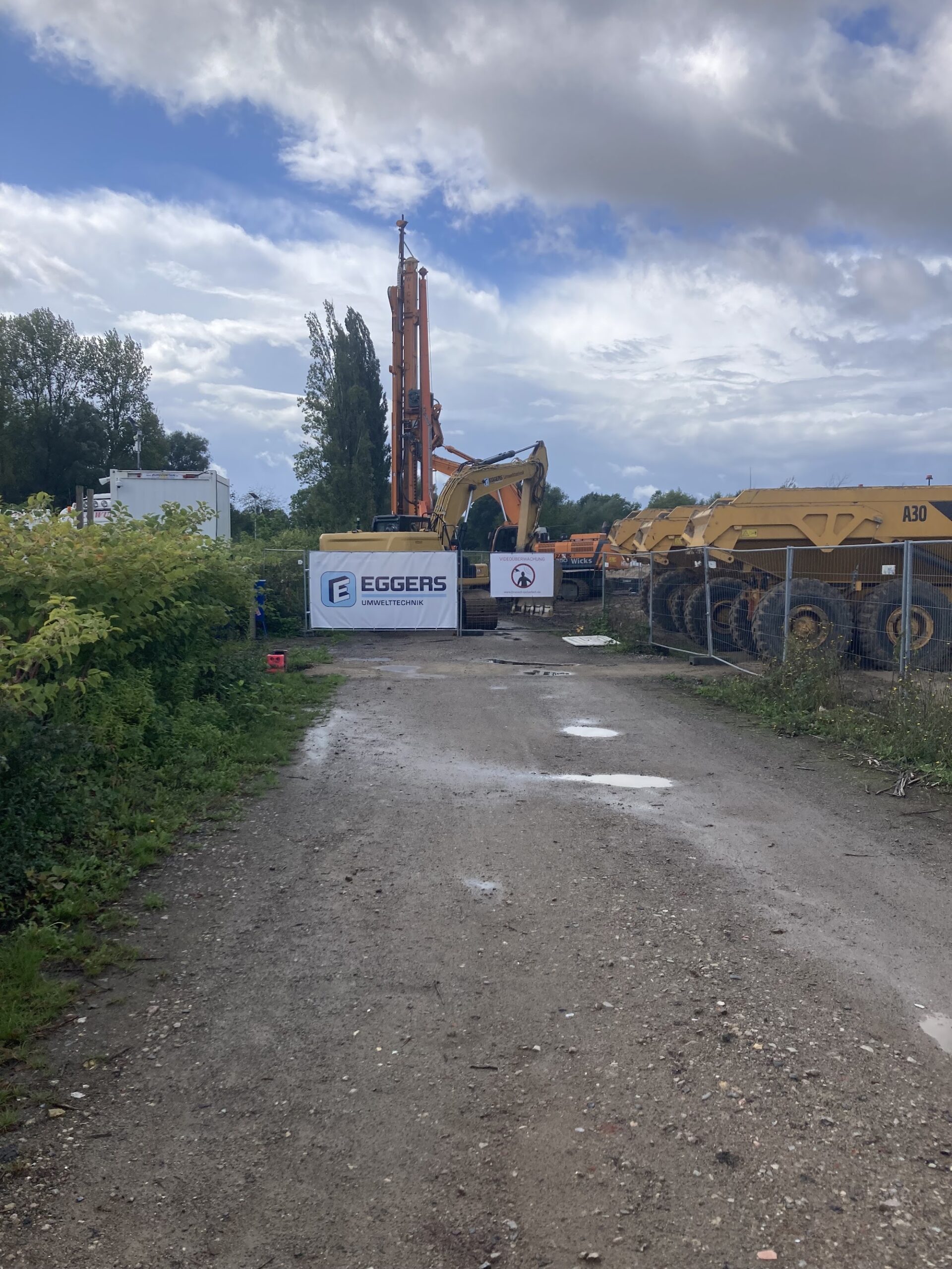 Zufahrtsweg zum Baufeld mit Baumaschinen im Hintergrund