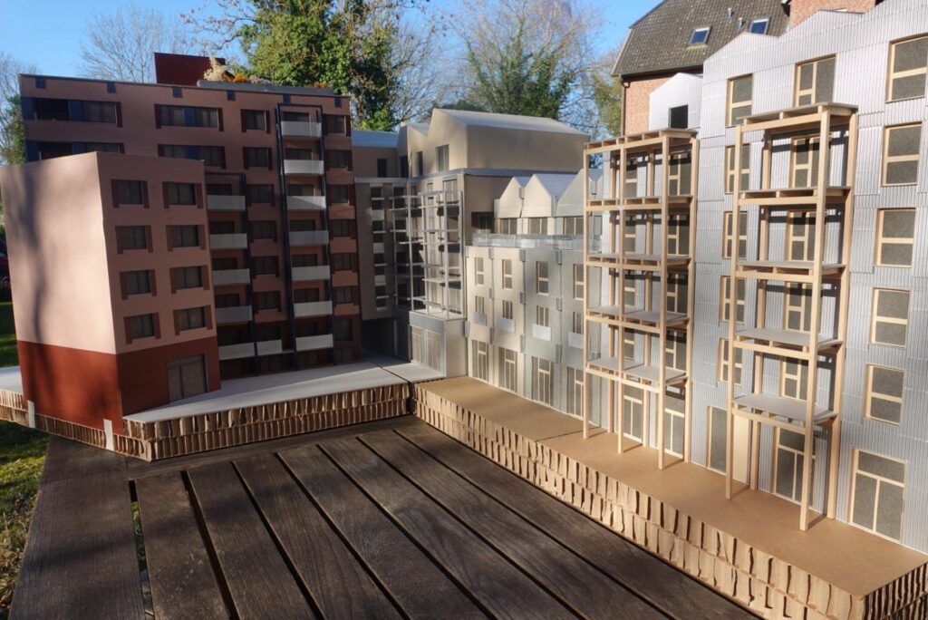 Foto des Architekturmodells: Blick in den Innenhof, links Haus A, rechts Haus F mit Holzbalkonen