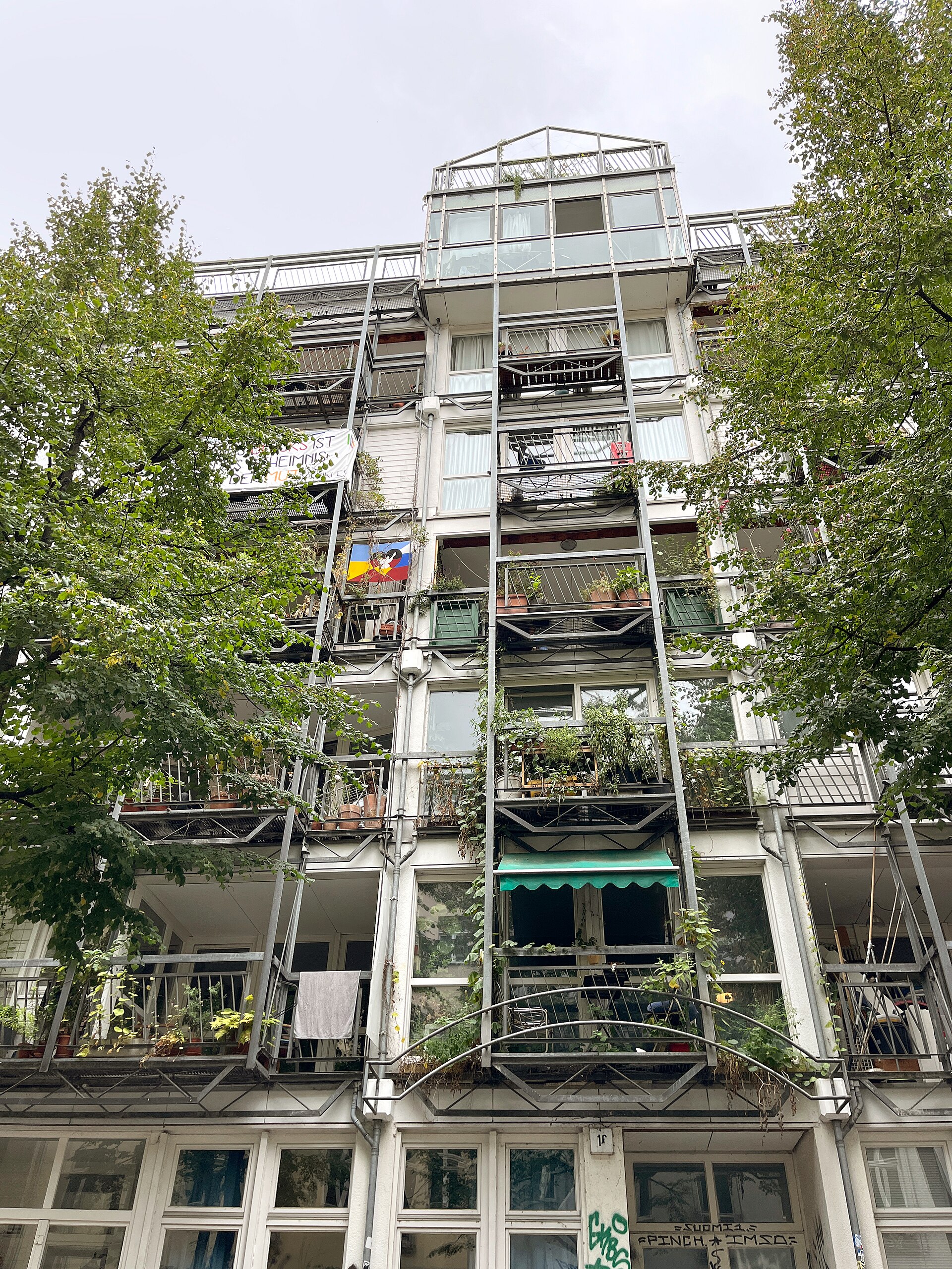 Wohnhaus mit offener Stahl-Regalstruktur und üppig bepflanzten Balkonen in Berlin-Kreuzberg